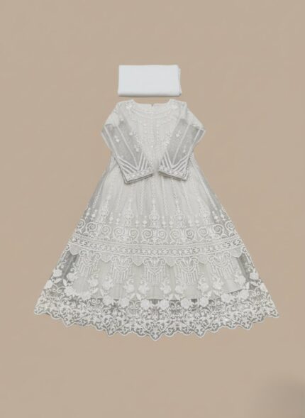 White embroidered net maxi dress with intricate design and a flowing silhouette, next to folded plain white fabric.