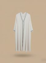 Woman abaya in sand beige, open-front kimono sweater cut, side pockets and belt shown on model standing against neutral wall