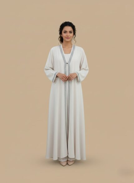 Woman abaya in sand beige, open-front kimono sweater cut, side pockets and belt shown on model standing against neutral wall
