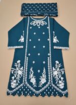 Full-length image of a woman wearing an embroidered cotton teal suit with detailed white floral embroidery on the tunic and trousers, paired with a matching printed dupatta. The outfit is made of cotton and is suitable for formal occasions.