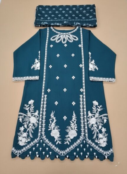 Full-length image of a woman wearing an embroidered cotton teal suit with detailed white floral embroidery on the tunic and trousers, paired with a matching printed dupatta. The outfit is made of cotton and is suitable for formal occasions.