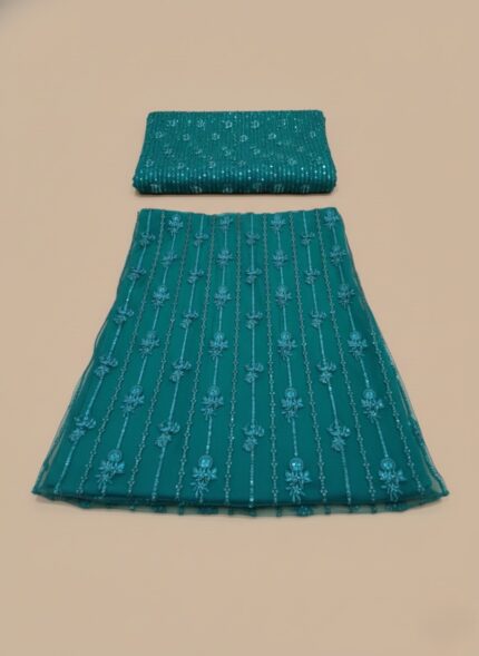 unstitched embroidered teal net lehenga fabric set. The main, larger piece for the lehenga/skirt shows detailed vertical floral patterns in teal thread and sequins. A smaller, matching piece for the top/blouse is folded on top, confirming the Embroidered Teal Net Lehenga Fabric description.