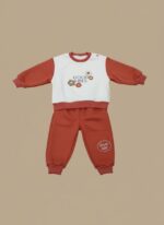 Lay-flat studio shot of the complete two-piece "Good Vibes" baby outfit set, showing a color-blocked sweater top and matching solid rust-colored joggers.