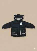 Front view of a young child wearing a black Kids Dog Puffer Jacket with a hood featuring dog ears and a white dog graphic on the chest, along with pockets marked "DOG" with a paw print.