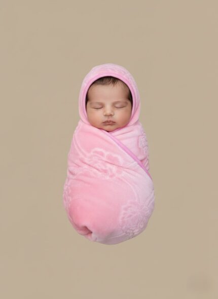 Pink baby blanket with hood, ultra-soft coral fleece with embossed rose pattern and pink trim, folded neatly on a neutral background, for baby girls.