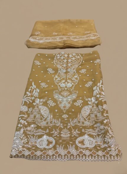 A highly detailed, unstitched Mustard Chiffon Embroidered Dress material featuring heavy, intricate white threadwork and subtle gold accents, laid flat with a matching embroidered dupatta/pallu piece above it. Includes raw silk trouser material