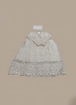 A flat lay image of a mauve embroidered net maxi dress with a short jacket-style bodice and a flowing skirt, accompanied by a matching plain mauve net dupatta, all laid out on a beige background.