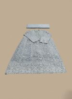 A flat lay image of a mauve embroidered net maxi dress with a short jacket-style bodice and a flowing skirt, accompanied by a matching plain mauve net dupatta, all laid out on a beige background.