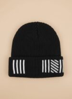 Image of a man wearing a black ribbed beanie with white vertical stripes and a diagonal patterned section on the cuff.