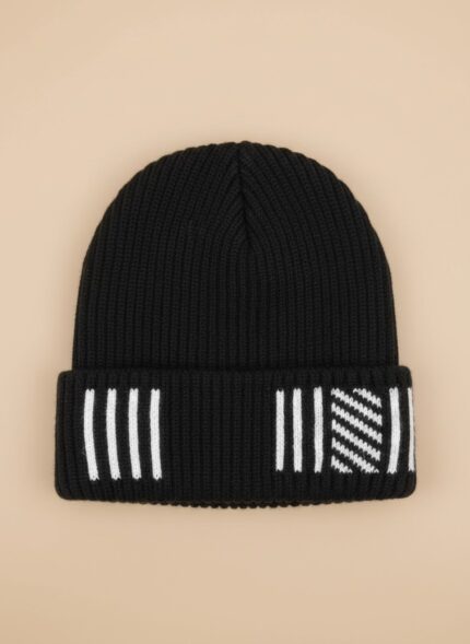 Image of a man wearing a black ribbed beanie with white vertical stripes and a diagonal patterned section on the cuff.