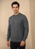 Men's dark grey textured knit crew neck sweater with a small emblem, worn by a man.