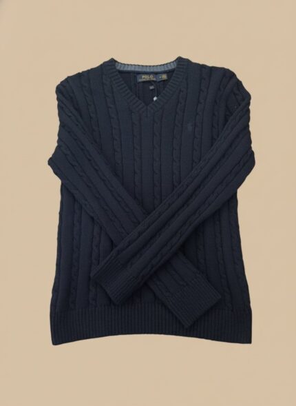 Men's navy cable knit V-neck sweater with an intricate textured pattern, worn by a model and layered over a light blue shirt.