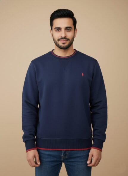 Men's navy crew neck sweater with red striped trim on the collar, cuffs, and hem, worn by a model.