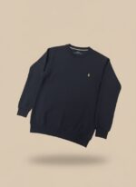 Men's navy textured crew neck sweater with a delicate pattern and a yellow embroidered logo, worn by a model.