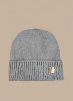 Image of a man wearing a grey ribbed beanie with a decorative V-shaped emblem with green and red accents.