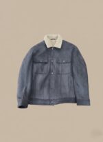 Men's dark blue suede trucker jacket with a cream sherpa collar and lining, featuring chest pockets and front button closure, displayed on a light background.