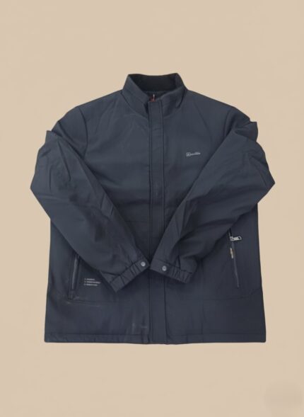 A dark grey or black men's waterproof outdoor jacket with a stand-up collar, zippers, and a subtle logo on the chest, laid flat against a light background.