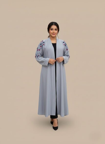 Neutral woman abaya in matte crepe, open-front kimono sweater silhouette, side pockets and belt shown on model against light grey wall