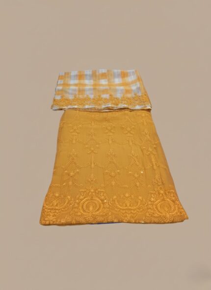 Mustard yellow heavily embroidered chiffon dress unstitched 3 PC fabric and checkered chiffon dupatta laid on a plain background.