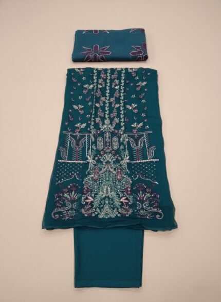 NUREH The Secret Garden NL-29 Tiara Unstitched Luxury Formals Embroidered Chiffon Suit in teal and maroon, with detailed hand embroidery on chiffon, an embroidered organza laser dupatta, and screen-printed raw silk trousers, worn by a female model.