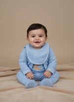 Newborn baby blue teddy bear outfit set with 7 pieces including a long-sleeve top, footed sleeper, hooded jacket, pants, bib, and swaddle blanket, all made of soft cotton with teddy bear embroidery.