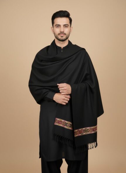 Black men's shawl with colorful embroidered stripe, folded neatly on a light background.