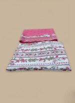 Pink Floral Lawn Suit 3-piece unstitched fabric with large pink and white floral print and solid pink base fabric on a wooden display table.