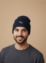 Puma Men's Navy Blue Winter Sports Beanie Cap with grey "SPORTS" stripe and white Puma logo embroidery on ribbed knit fabric.