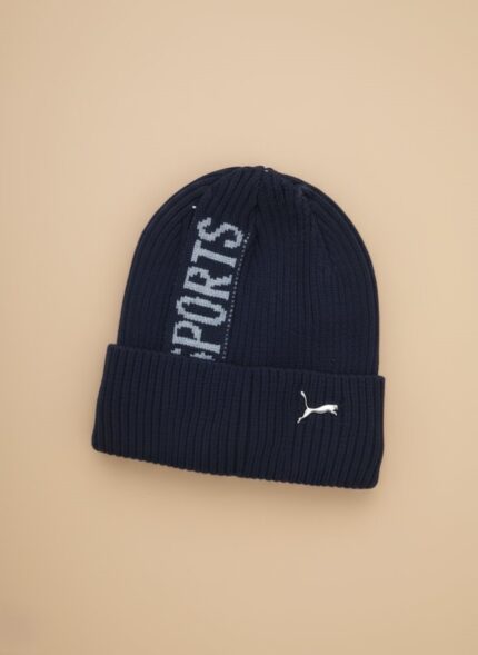 Puma Men's Navy Blue Winter Sports Beanie Cap with grey "SPORTS" stripe and white Puma logo embroidery on ribbed knit fabric.