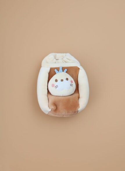 White baby pillow with a colorful car, palm tree, and sun illustration, set against a light brown background.