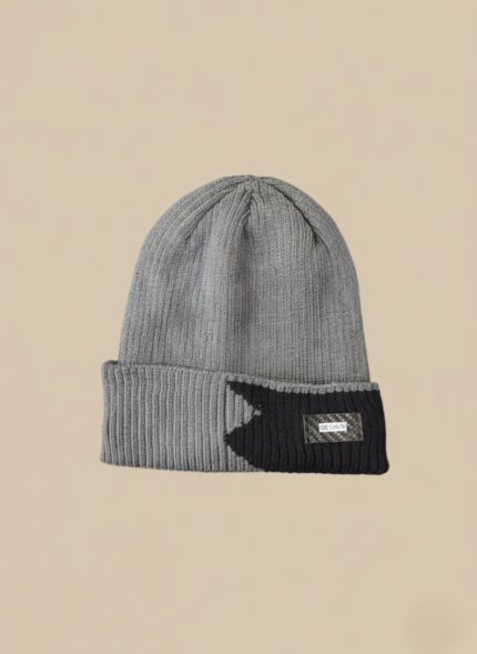 Grey ribbed beanie hat with black contrast detail and design patch on a neutral background.