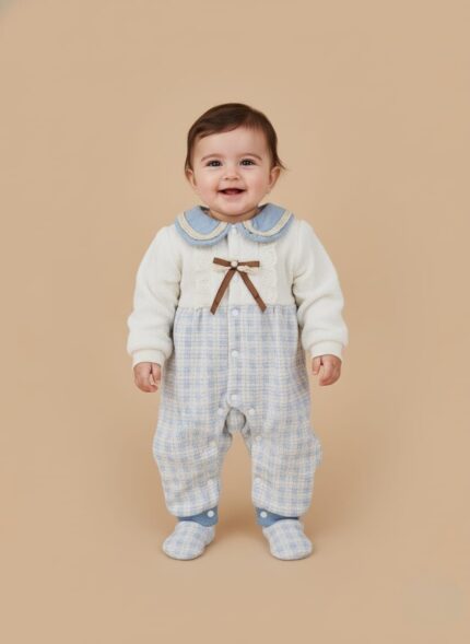 Cute baby romper with white knit upper, blue plaid lower, blue crochet collar, lace, and brown bow.