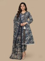 Full-length image of a woman wearing a navy blue Women's Floral Suit with an all-over floral printed long-sleeve tunic featuring lace trim and a tassel, matching patterned trousers, and a printed dupatta.
