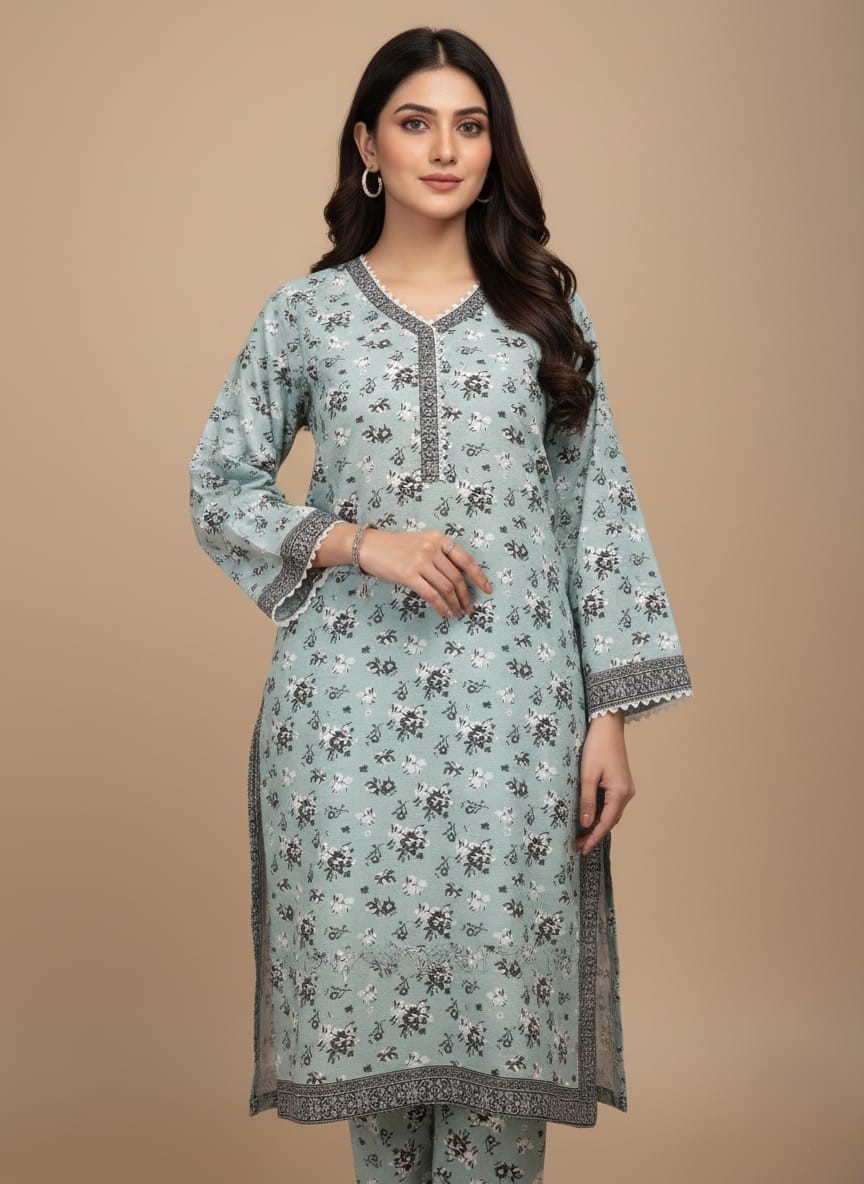 Women's Floral Suit | Light Blue Tunic & Trousers Half-length image of a woman wearing a light blue Women's Floral Suit with an all-over black and white floral printed long-sleeve tunic featuring an embroidered V-neckline, cuffs, and hem, and matching patterned trousers.