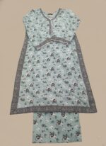 Half-length image of a woman wearing a light blue Women's Floral Suit with an all-over black and white floral printed long-sleeve tunic featuring an embroidered V-neckline, cuffs, and hem, and matching patterned trousers.