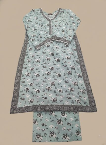 Half-length image of a woman wearing a light blue Women's Floral Suit with an all-over black and white floral printed long-sleeve tunic featuring an embroidered V-neckline, cuffs, and hem, and matching patterned trousers.