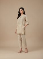 Beige women's cropped trousers with decorative side loop detail and elastic waist.