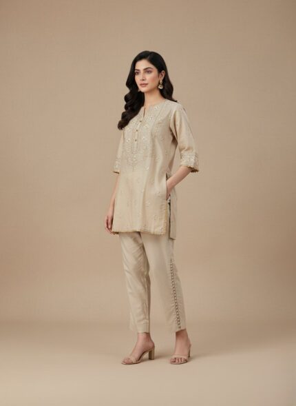 Beige women's cropped trousers with decorative side loop detail and elastic waist.
