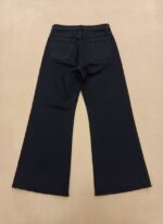 Back view of women's black flared jeans, high-waisted with a wide leg.