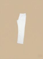 White slim-fit ankle pants for women, folded neatly on a light brown surface, showcasing their fabric and cut.