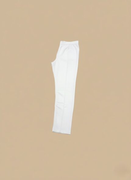 White slim-fit ankle pants for women, folded neatly on a light brown surface, showcasing their fabric and cut.