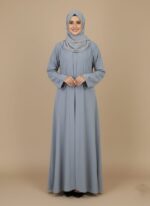 Classic grey simple abaya design with a subtle pleated front, modeled by a smiling woman. A comfortable and elegant modest Islamic sweater.