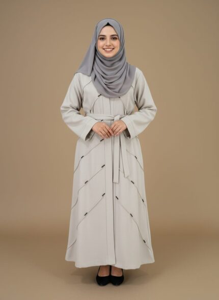 Elegant grey modest abaya dress with belted waist and intricate stitching, modeled by a smiling woman. A chic Islamic sweater for modern modest fashion.