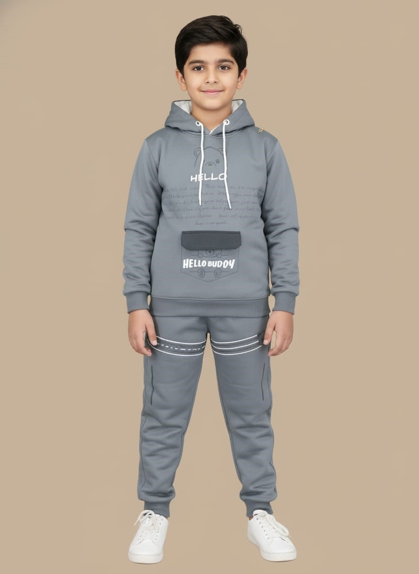 full grey tracksuit set, with hooded top 2 Happy boy in a full grey tracksuit set, consisting of a hooded top with bear graphic and "HELLO BUDDY" print, matching joggers with white stripes, and white sneakers.