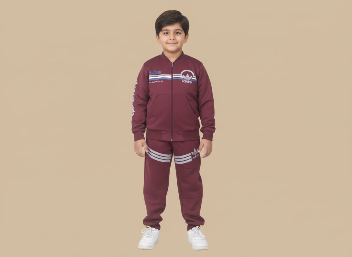 maroon sports tracksuit with a zip-up jacket Happy boy in a maroon sports tracksuit with a zip-up jacket and striped joggers, featuring sports branding