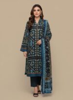 Full-length image of a woman wearing a black and blue Women's Ethnic Dress with intricate geometric patterns, consisting of a long-sleeve tunic, dark trousers, and a matching printed dupatta, standing against a beige background.