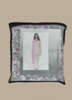 Full-length image of a smiling woman wearing a light pink Women's Floral Suit with a floral printed tunic, patterned trousers, and a pink and white striped dupatta, standing against a beige background.