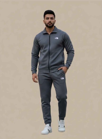 Main Image: Full view of Gelani's gray Tracksuit for Men with white logo branding. Jacket Detail: Close-up of the gray dry-fit jacket zipper and stand-up collar. Logo Detail: The North Face white logo on the chest of the gray men's tracksuit. Trousers View: Matching gray dry-fit trousers for men with elasticated waist and logo. Fabric Shot: High-quality gray stitched dry-fit material texture for winter athletic wear. Tracksuit for Men