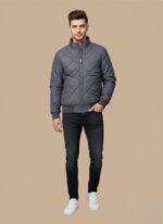 Men's grey diamond quilted jacket by Tommy Hilfiger on a blue surface.