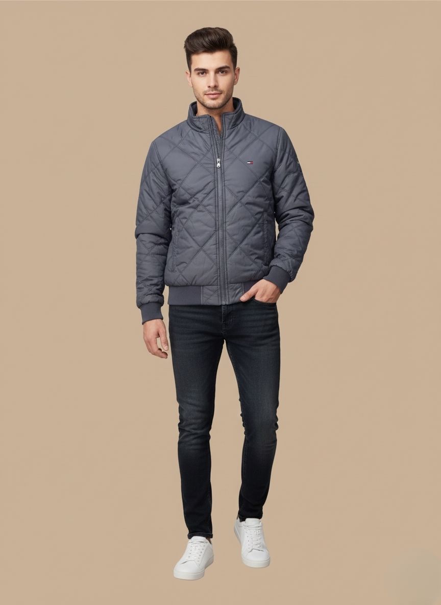 Men's grey diamond quilted jacket by Tommy Hilfiger on a blue surface.